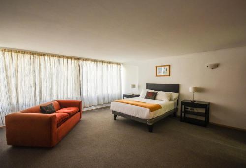 a hotel room with a bed and a couch at Hotel Nogales By Tempo Rent in Santiago