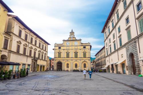 a building with a clock tower in the middle of a street at Dimora dei cesari in Città di Castello