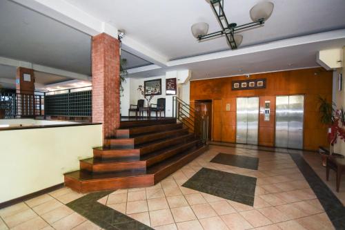 a lobby of a building with a staircase and a door at Hotel Nogales By Tempo Rent in Santiago