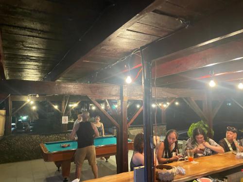 a group of people sitting around a pool table at Perla Negra Beachfront in Puerto Viejo