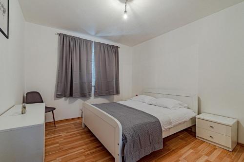 a bedroom with a white bed and a window at Holiday house with a parking space Zrnovo, Korcula - 21067 in Žrnovo