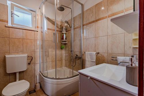 La salle de bains est pourvue de toilettes, d'une douche et d'un lavabo. dans l'établissement Holiday house with a parking space Zrnovo, Korcula - 21067, à Žrnovo