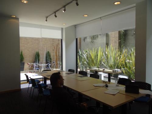 a meeting room with tables and chairs and a large window at Hotel bh Parque 93 in Bogotá
