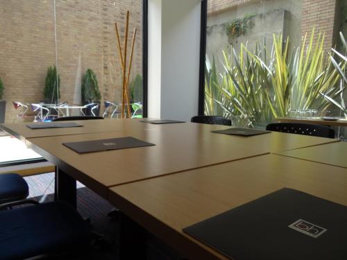 a conference room with tables and chairs and plants at Hotel bh Parque 93 in Bogotá