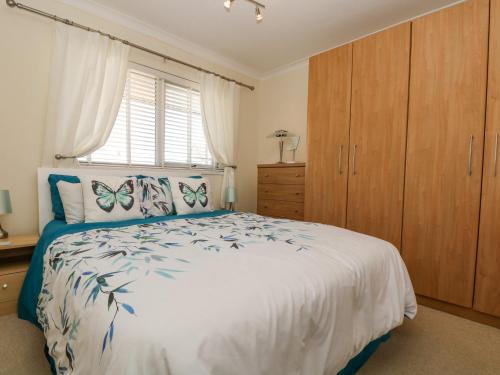 a bedroom with a bed with butterfly pillows on it at Respryn in Mevagissey