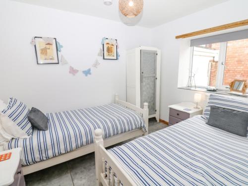 a bedroom with two beds and a window at The Milk Shed in Plymtree