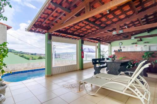 une terrasse avec une table, des chaises et une piscine dans l'établissement Casa da Cidinha, à Extrema