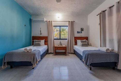 En eller flere senge i et værelse på KIN House casa de playa con alberca