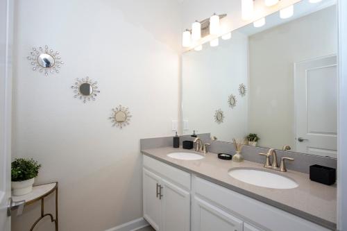un bagno con due lavandini e un grande specchio di Stunning 5 Bd Home w/ Pool Close to Disney 4822 a Kissimmee