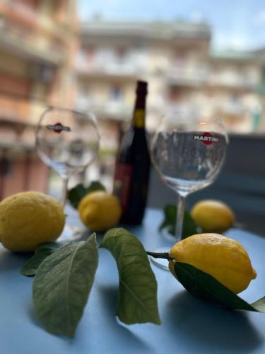 a table with two glasses and a bottle of wine and lemons at De Riso Apartments Luxury Amalfi Coast in Minori