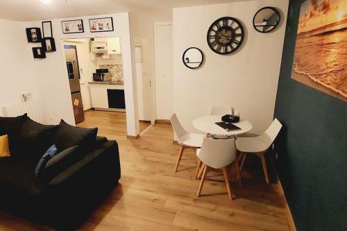 un salon avec un canapé, une table et des chaises dans l'établissement appartement cosy Strasbourg, à Strasbourg