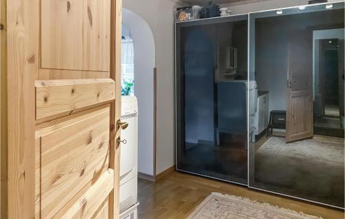 a kitchen with a glass refrigerator and a door at Amazing Apartment In Skrblacka With Kitchen in Skärblacka