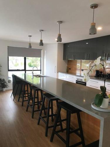 a large kitchen with a long table and some chairs at Tranquil Retreat 10 Min to Hobart-WIFI Smart TV in Hobart