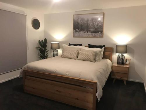 a bedroom with a large bed with two night stands at Tranquil Retreat 10 Min to Hobart-WIFI Smart TV in Hobart