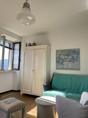 a living room with a green couch and a cabinet at Terrazza sul lago in Ameno