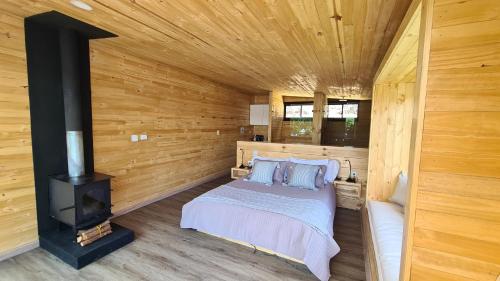 1 dormitorio con cama y estufa de leña en GLAMPING BY NAQUA, en Pantano Redondo