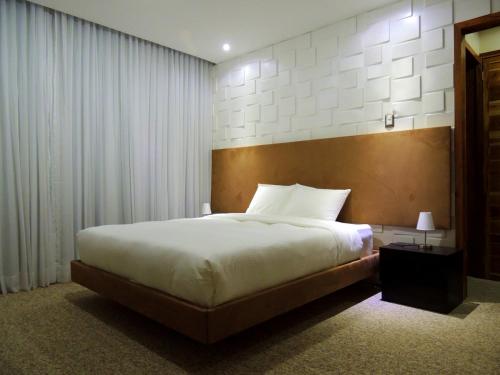 1 dormitorio con 1 cama grande con sábanas blancas en Grand Hotel Victoria en El Morro de Barcelona