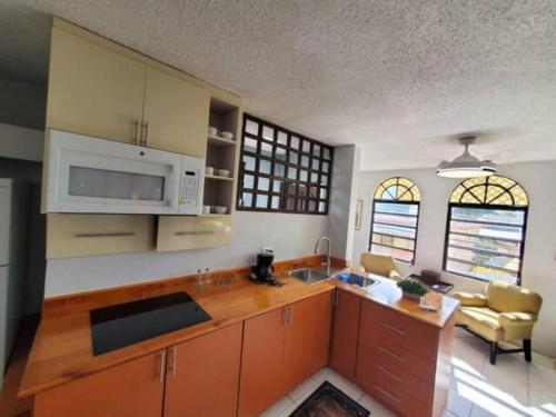 a kitchen with wooden cabinets and a counter top at Cepeda Economical 10 BR Compound in San Juan