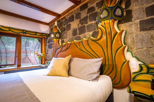a bedroom with a large bed in a stone wall at Casa Primal in San José de Maipo