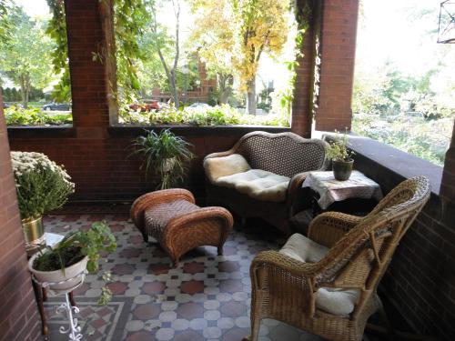 a patio with wicker chairs and chairs and a table at Lehmann House Bed & Breakfast in Saint Louis