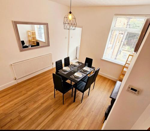 a dining room with a table and chairs in a room at Comfortable 2 Bed House Near City Centre and M1 in Leicester