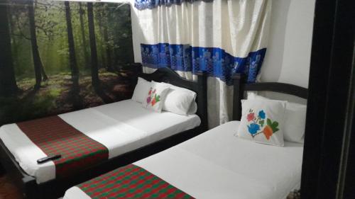 duas camas individuais num quarto com árvores em HOTEL NEIVA REAL em Neiva