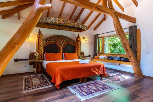 sypialnia z dużym łóżkiem z pomarańczową narzutą w obiekcie Casa Primal w mieście San José de Maipo