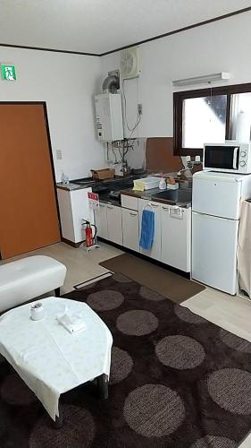 a living room with a table and a kitchen at Corpo Marika 0 in Hakodate