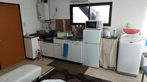una cocina con electrodomésticos blancos y una ventana en Corpo Marika 0, en Hakodate