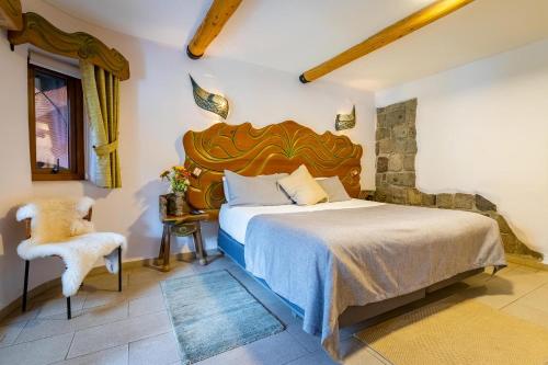a bedroom with a large bed and a chair at Casa Primal in San José de Maipo
