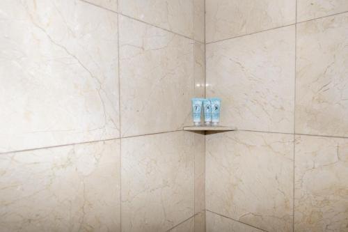 baño con paredes de mármol blanco y estante con 2 aseos en Parisian Hotel, en Miami Beach