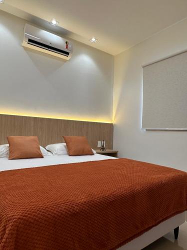 1 dormitorio con 1 cama con manta roja en Concierge House Espetacular em Condomínio Fechado, en Marabá