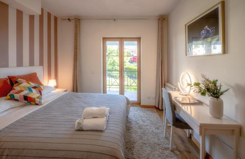 a bedroom with a bed and a desk and a window at Casa do Fotógrafo in Sintra