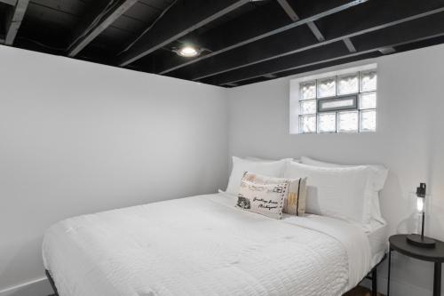 Cama blanca en habitación blanca con ventana en Chic Industrial 3 Bdr Home With Game Room, en Ferndale