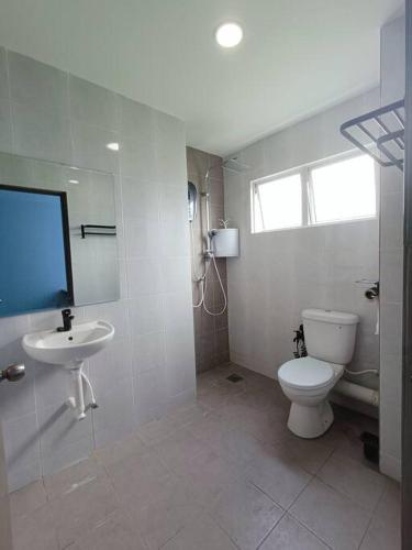a white bathroom with a toilet and a sink at Joyful Sitiawan skygarden swimming pool in Seri Manjung