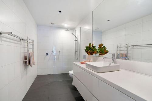 a white bathroom with a sink and a toilet at Steam Packet Wharf in Port Fairy