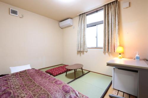 千葉市にあるプチバスケットのベッドと窓が備わる小さな客室です。