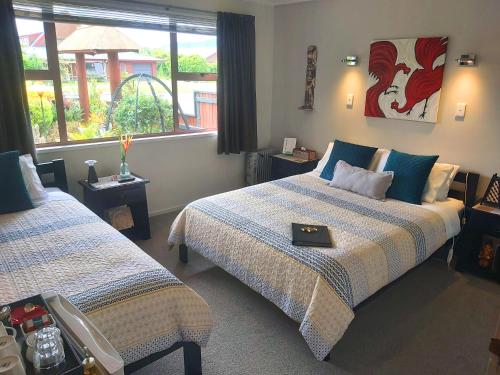 Habitación de hotel con 2 camas y ventana en Rotorua City Homestay, en Rotorua