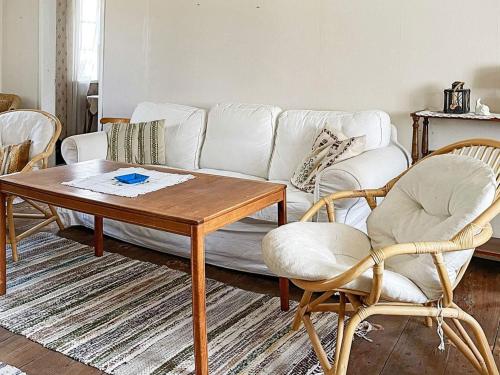 a living room with a white couch and a table at 9 person holiday home in Ljungbyhed-By Traum in Ljungbyhed