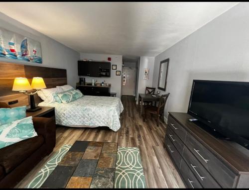 Habitación de hotel con cama y TV de pantalla plana. en Upgraded Studio at Landmark Resort ! 17 pools, lazy rivers, jacuzzis! 814 en Myrtle Beach