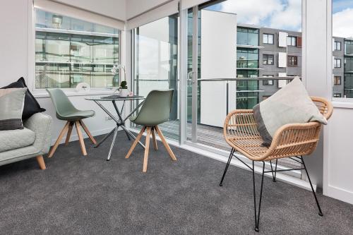 un salon avec des chaises et une table dans l'établissement QV Stays Cosy in the Viaduct, à Auckland
