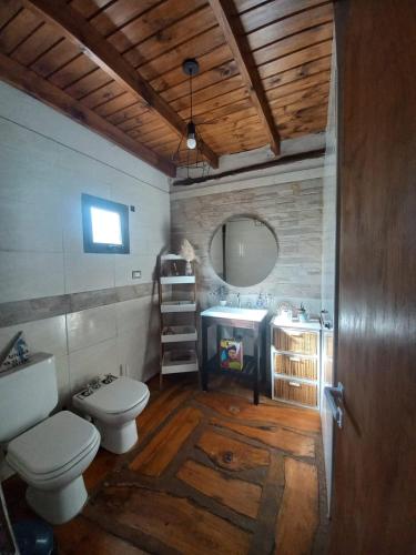 a bathroom with two toilets and a sink and a mirror at Espejos de monte in San Miguel del Monte