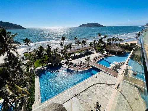 an aerial view of a resort with a swimming pool and the beach at Lujoso departamento frente al mar/camino al mar in Mazatlán