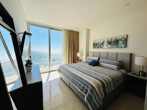 a bedroom with a bed with a view of the ocean at Lujoso departamento frente al mar/camino al mar in Mazatlán