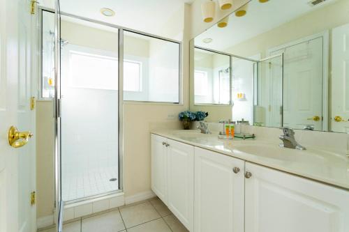 - Baño blanco con 2 lavabos y ducha en Gorgeous 4 Bedroom w/ Pool Close to Disney 920, en Kissimmee
