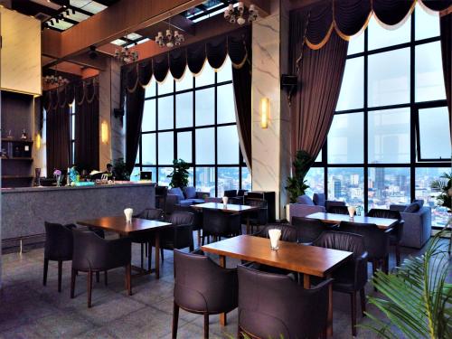 een restaurant met tafels en stoelen en grote ramen bij Legend Hotel and Resort in Sihanoukville