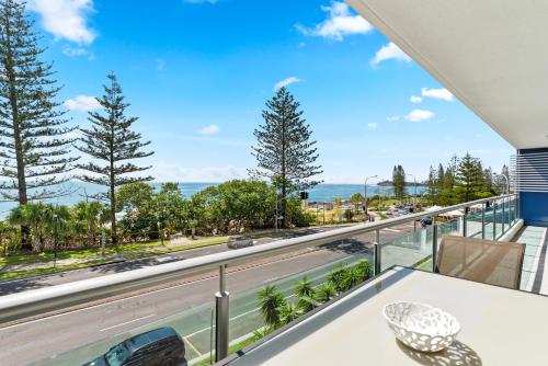 a balcony with a table and a view of the ocean at Northwind Beachfront Apartments in Mooloolaba
