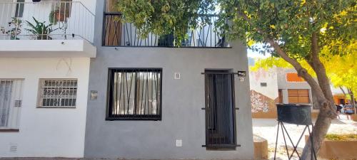 a white building with a black door and a tree at Utopia byb in Capilla del Monte