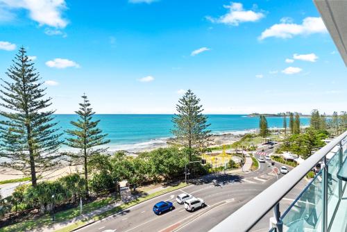 a balcony with a view of a road and the ocean at Northwind Beachfront Apartments in Mooloolaba