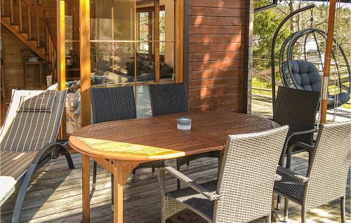 een houten tafel en stoelen op een patio bij Beautiful Home In Frgelanda With 3 Bedrooms And Wifi in Muberg